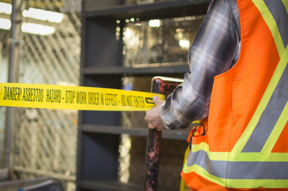 Photo of worker in high-vis vest in front of hazard tape