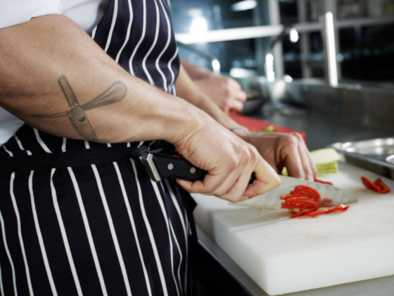 Photo of hands of chef cutting up food