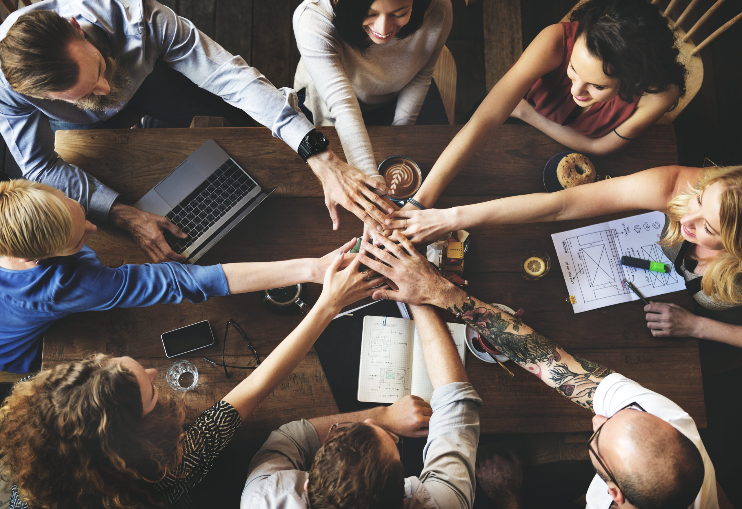 Group of people with hands together in centre of table