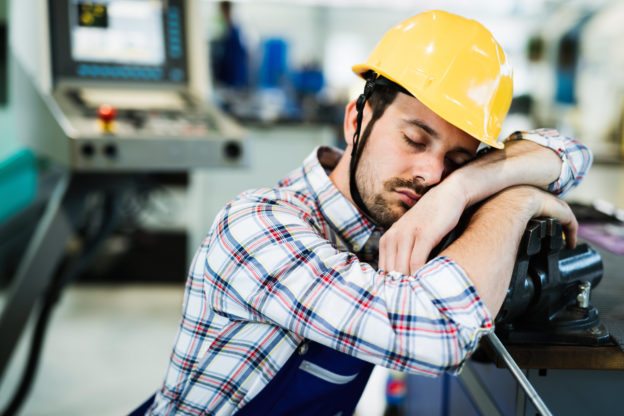 Photo of worker in hardhat sleeping on the job