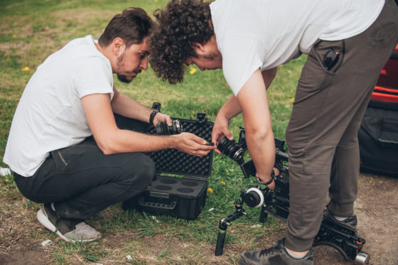 Photo of two young men changing lenses on a camera