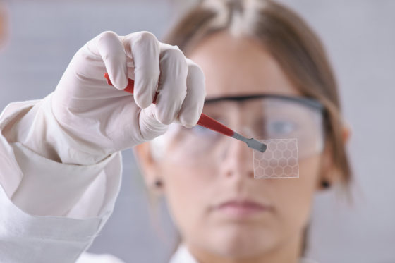 Photo of lab tech holding material with tweasers