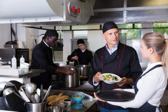Photo of chef and staff in kitchen of restaurant