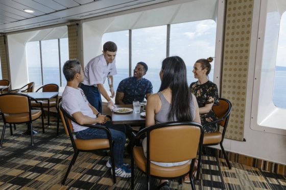 Photo of server, with passengers seated at a table, at the Pacific Buffet on a BC Ferries vesssel