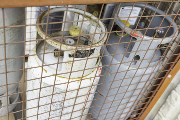 Photo of two propane tanks stored in a wire cage