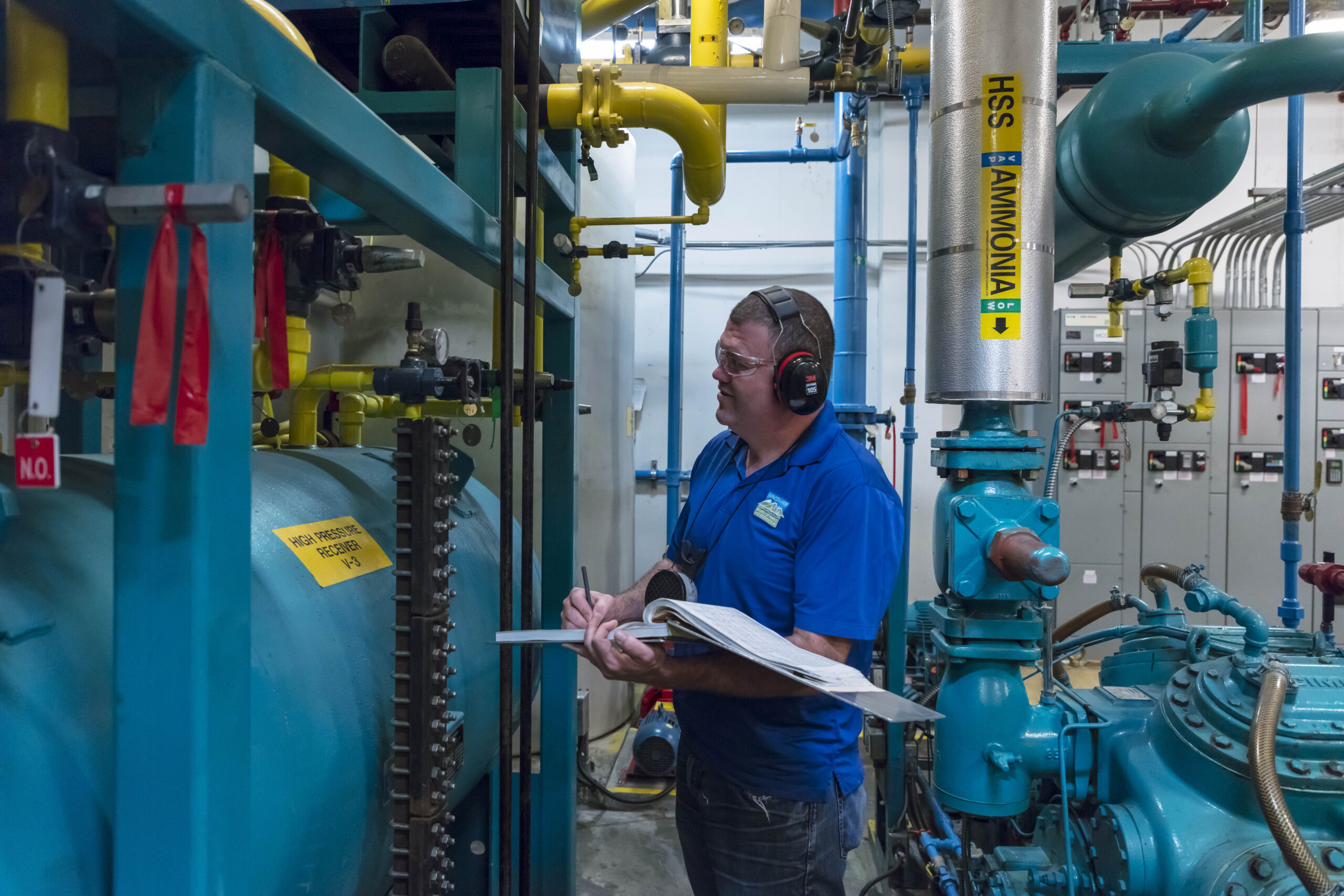 Photo of a worker checking an industrial refrigeration system