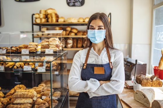 Photo of bakery shop owner wearing a mask to comply with health orders to reduce transmission of COVID-19.