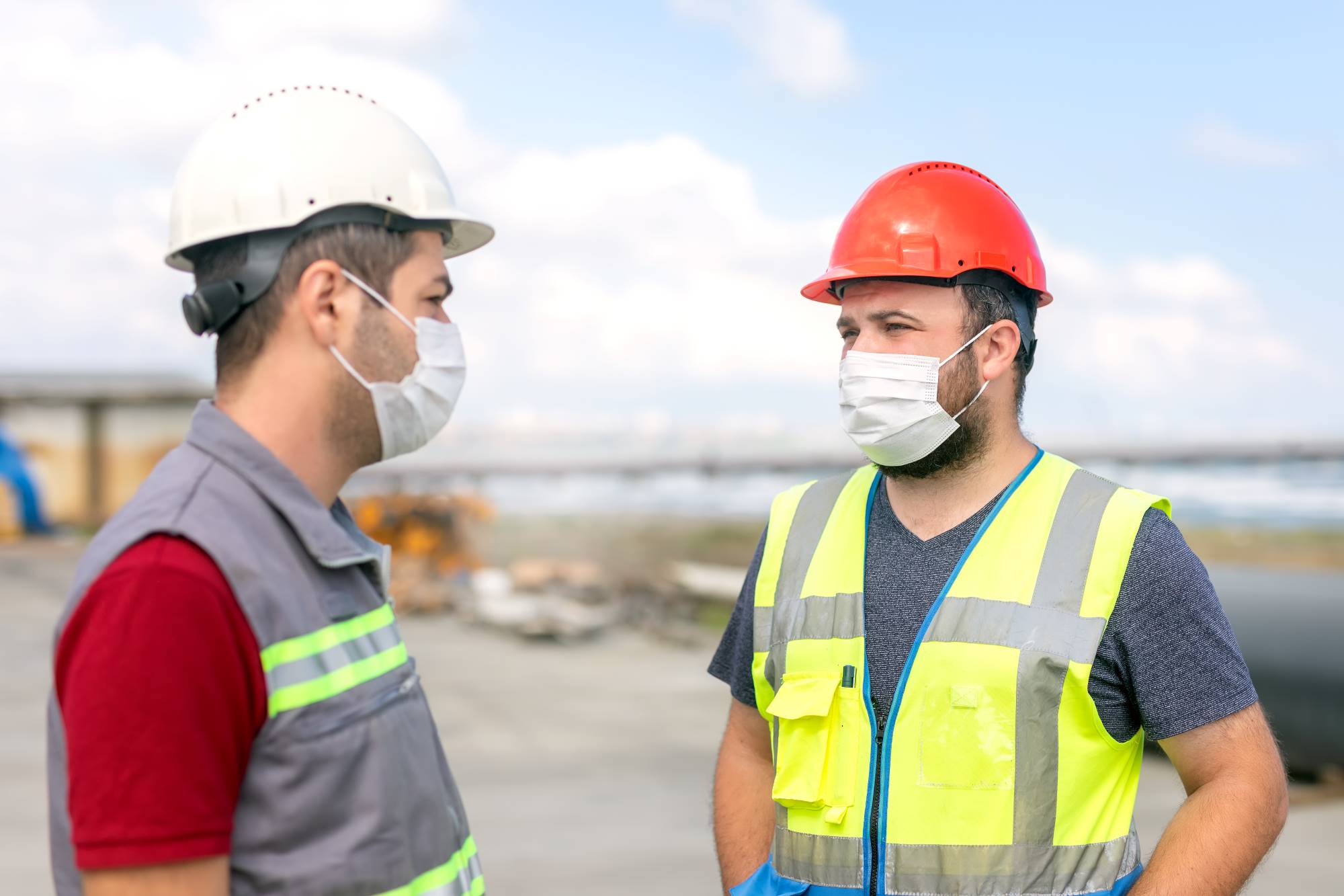 Photo of prime contractor and construction worker discussing and wearing masks to protect against COVID-19.