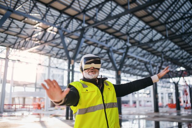 Photo of engineer using virtual reality goggles outdoors on construction site