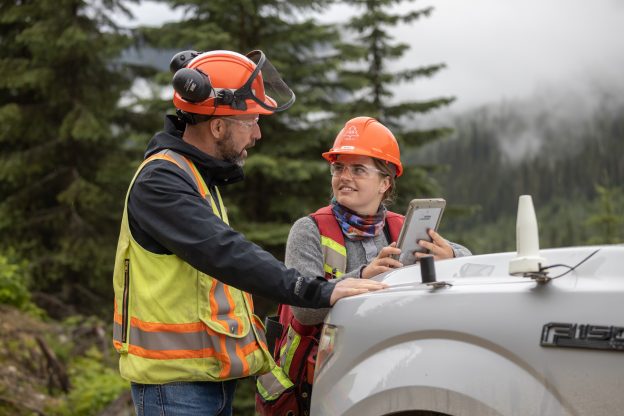 Photo of two people working in forestry looking at a tablet