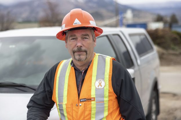 Photo of Carl Howells in a WorkSafeBC vest and hard hat.