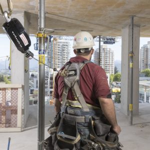 Photo of man at construction site with fall protection attached.