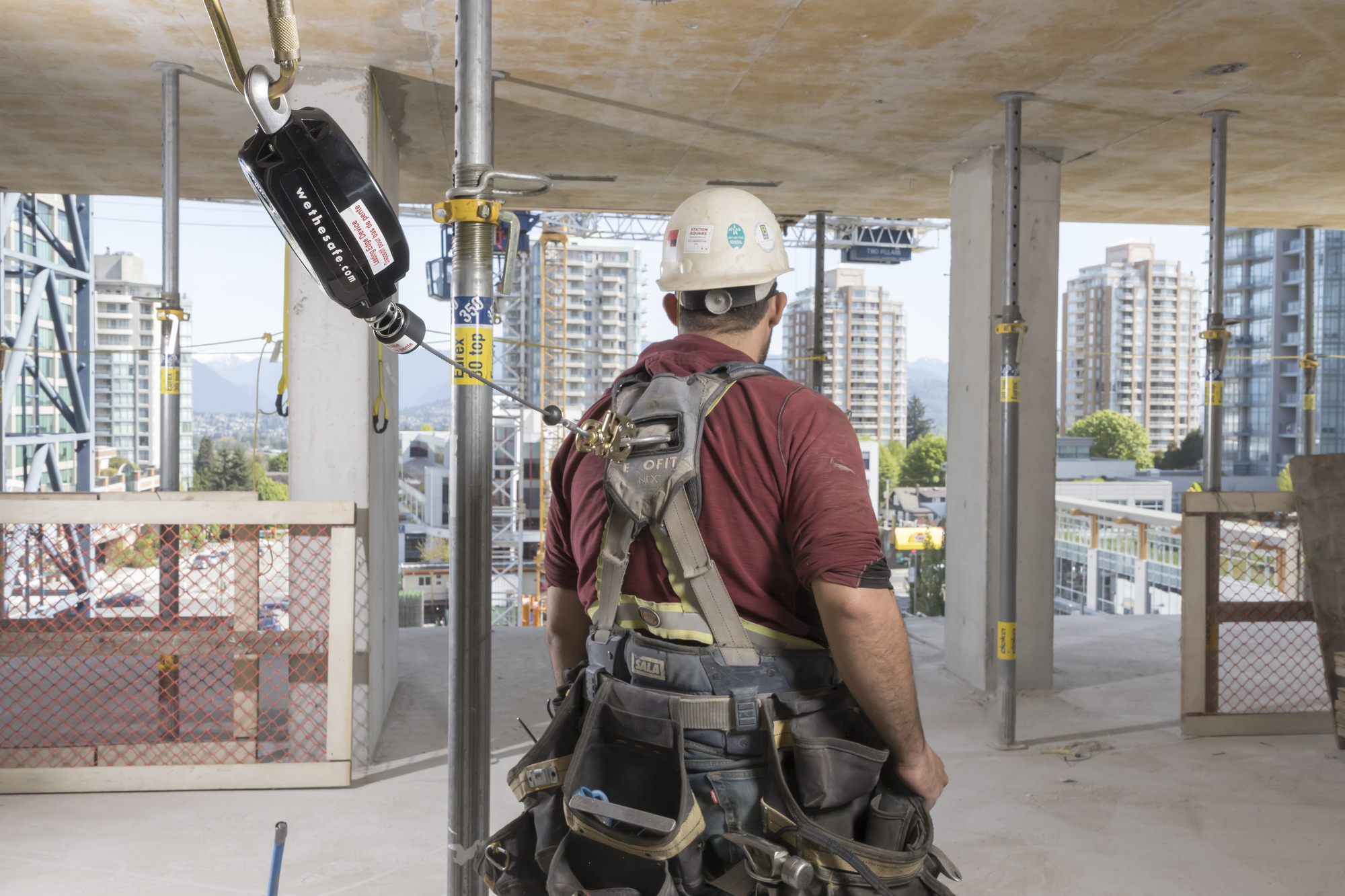 Photo of man at construction site with fall protection attached.