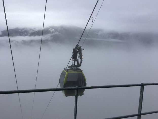 Photo of a worker fixing a ski gondola and dressed to prevent cold stress.